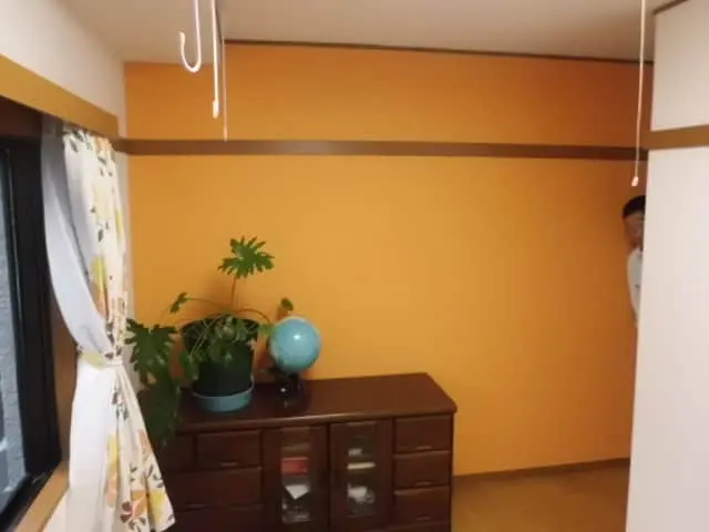 壁にオレンジのアクセントクロスを貼った様子