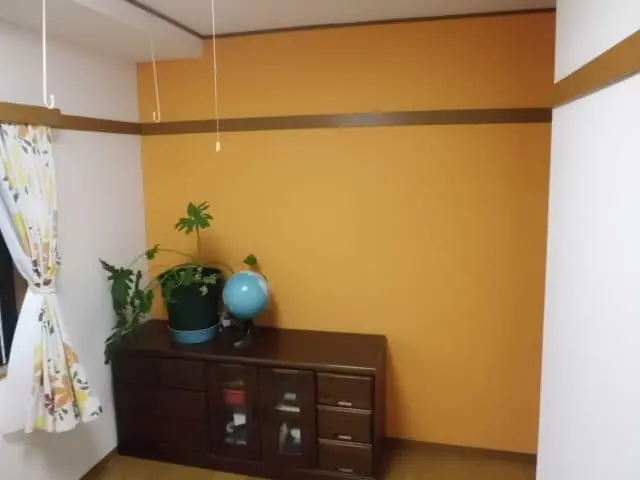 オレンジのアクセントクロスを取り入れて壁紙を貼り替えた部屋
