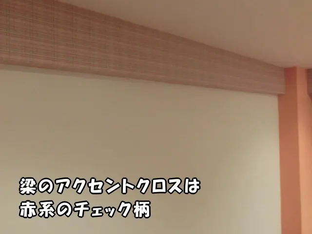 江東区のマンションで、子供部屋の梁に赤系のチェック柄のアクセントクロスで貼り替えた様子。