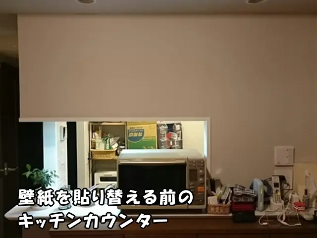 中央区のマンションで、壁紙を貼り替える前の白無地の壁紙が貼ってあるキッチンカウンターの様子。