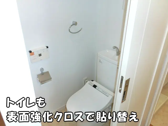 白い表面強化クロスで貼り替え、明るく清潔な印象のトイレの様子。