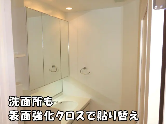 白い表面強化クロスで貼り替え清潔感あふれる洗面所の様子。