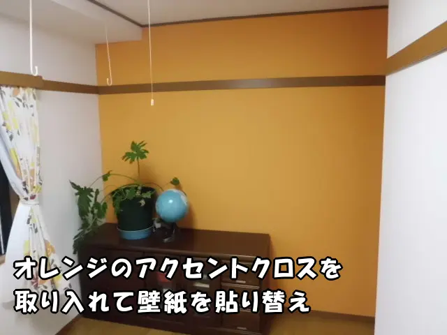 一戸建てで、オレンジのアクセントクロスを取り入れて壁紙を貼り替えた洋室。