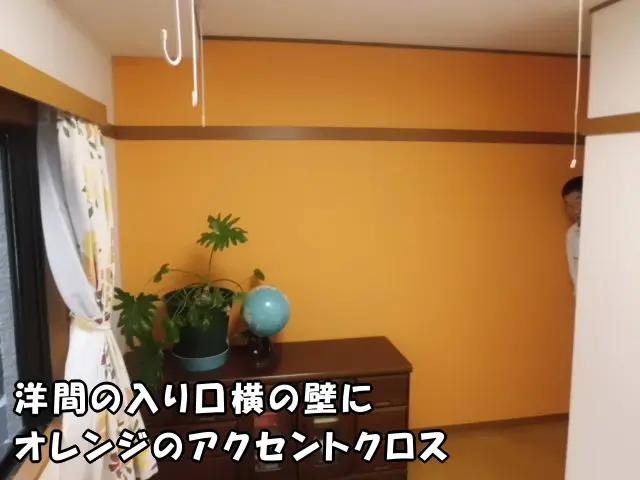 一戸建てで、洋室の壁紙リフォーム。壁にオレンジのアクセントクロスを貼った様子。