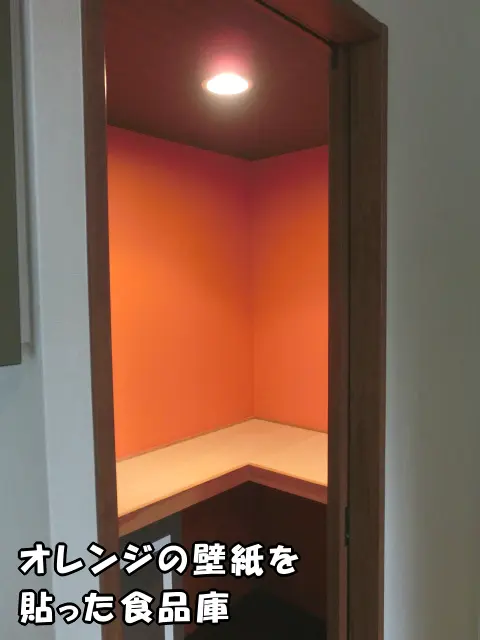 オレンジの壁紙を貼った食品庫の様子