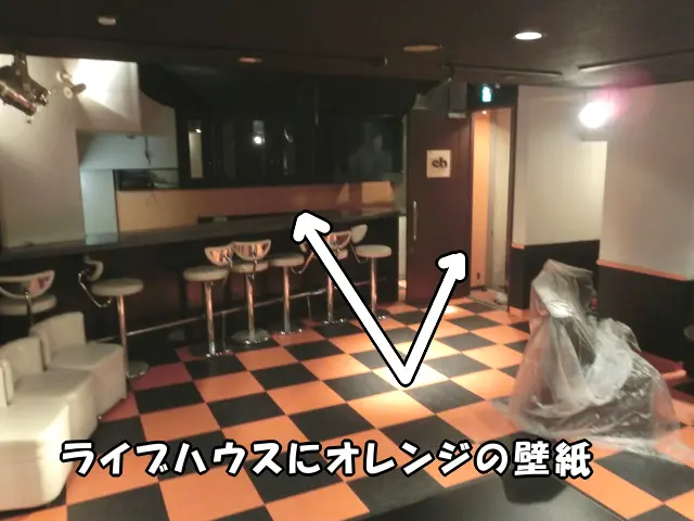 ライブハウスにオレンジの壁紙を貼った様子