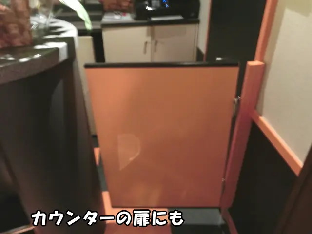 カウンターの扉にオレンジの壁紙を貼った様子