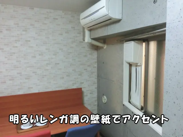 アクセントに明るいレンガ調の壁紙を貼った様子