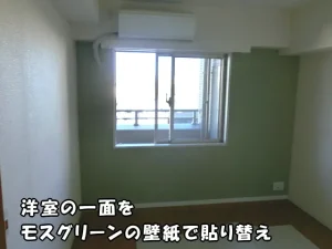 洋室の壁の一面をモスグリーンの壁紙で貼り替えた様子